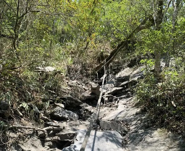 steep trail with rope hanging down