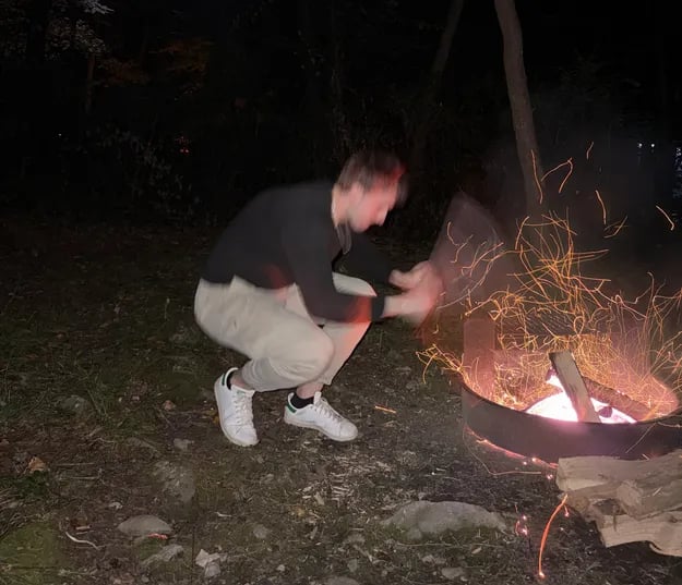 Me fanning the fire with a plastic container lid